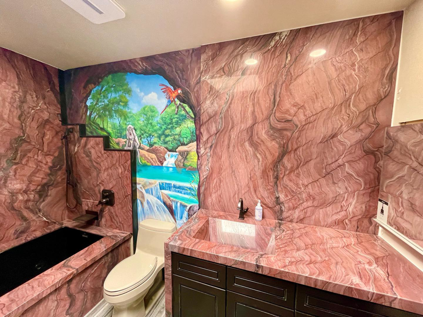 A renovated bathroom with custom stone walls, built-in tub, toilet, and stone vanity by Dorado Stone Inc. in Tucson, AZ.