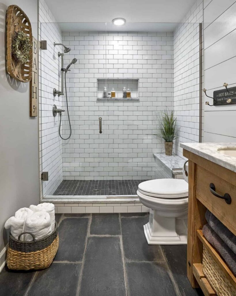 A modern bathroom renovation with white subway tile shower and dark floor by Four Seasons Building & Remodeling in Mauldin, SC.
