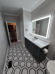 Stunning bathroom renovation with new hexagonal tile, vanity, and mirror by Hollis Construction in Nashville, TN.