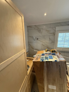 A bathroom undergoing renovation with new wall tiling and construction materials by D&J's Construction Services LLC in Denver, CO.