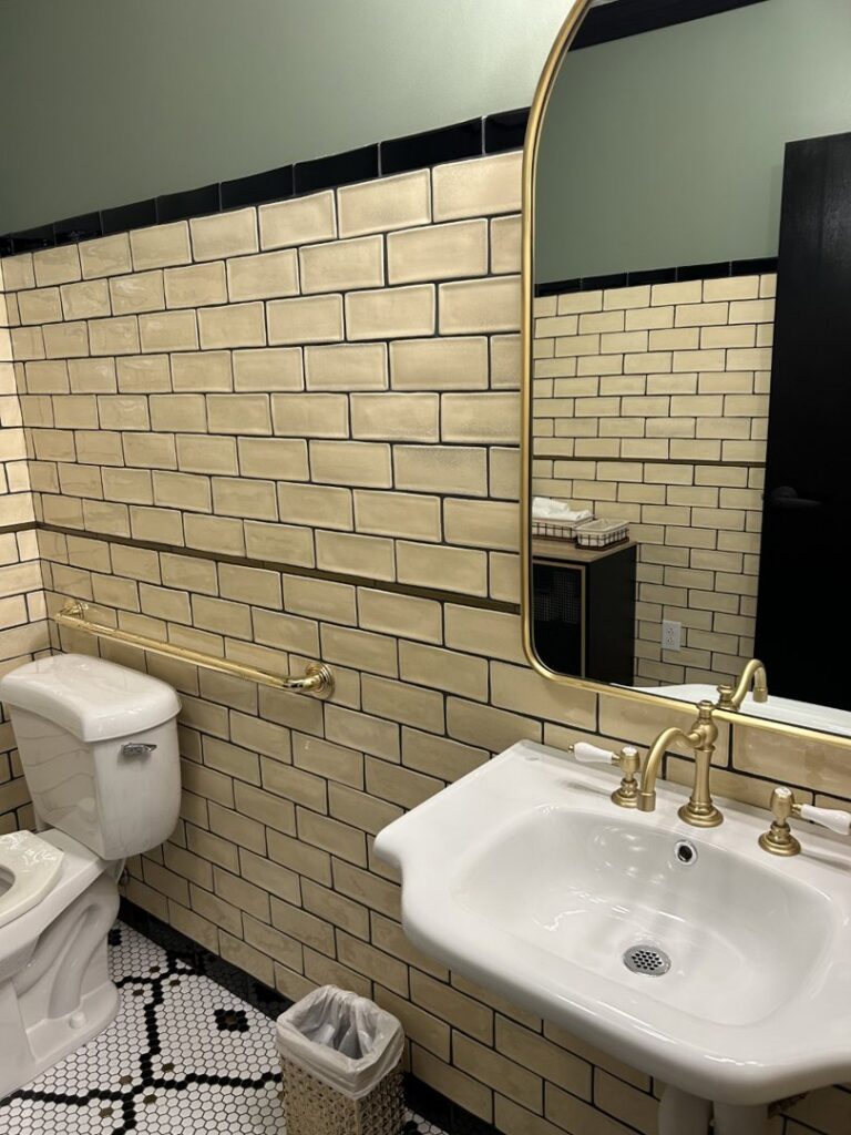 A newly renovated bathroom featuring subway tiling, a pedestal sink, and a grab bar by Shaub Construction Company, Inc. in Brentwood, TN.
