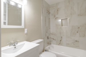 A beautifully renovated bathroom with new tiling, vanity, toilet, and tub installed by SSS Solutions, LLC in Mobile, AL.