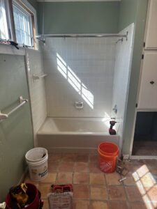 Bathroom renovation in progress with tools, bathtub, and tiled walls by KG Handyman & Remodeling in Vilonia, AR.
