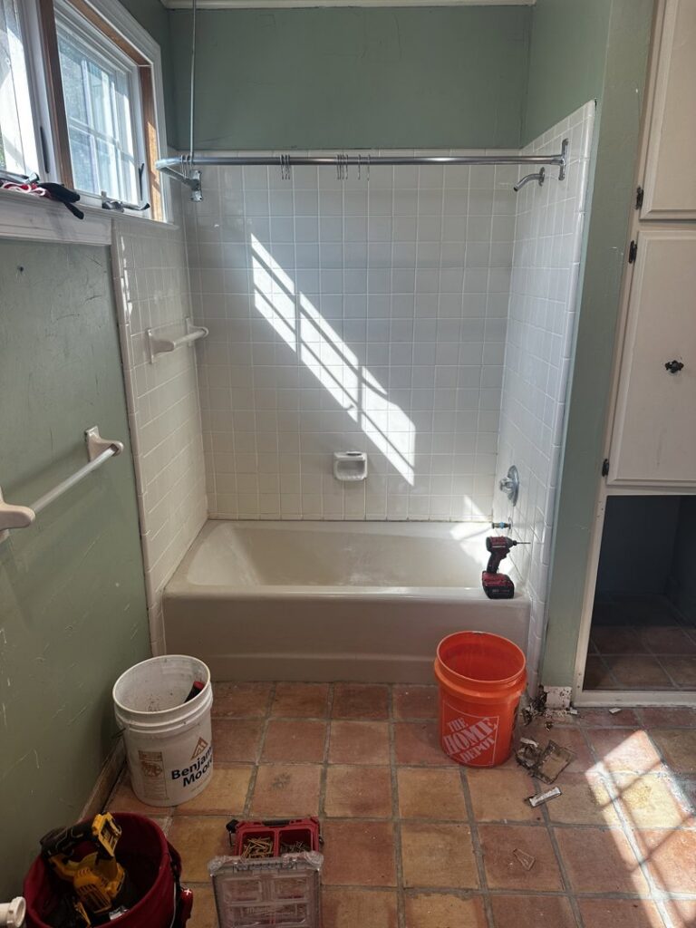 Bathroom renovation in progress with tools, bathtub, and tiled walls by KG Handyman & Remodeling in Vilonia, AR.