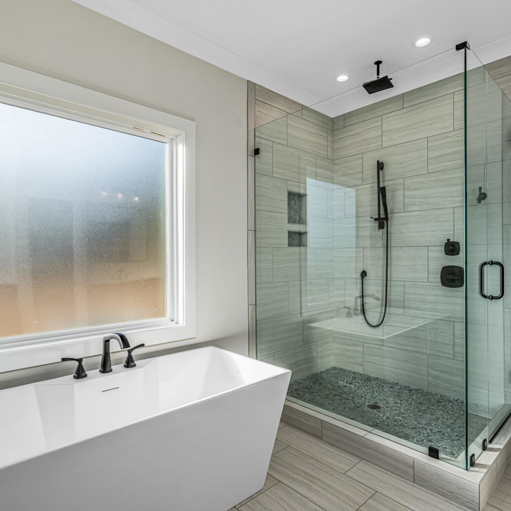 A modern bathroom renovation with a freestanding tub and glass-enclosed walk-in shower by Mitchco, Inc. in Winston-Salem, NC.