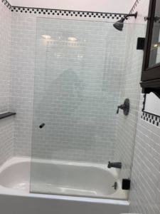 Bathroom renovation with a bathtub, white subway tiles, and a new glass shower screen by MTI Carpentry in Jersey City, NJ.