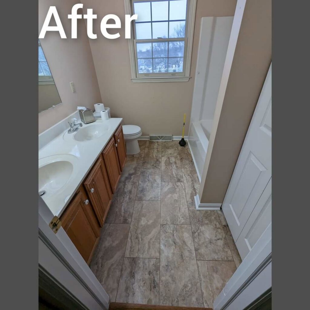 A completed bathroom renovation with new vanity and tiled floor by Adam's Handyman and Contracting in Lancaster, PA.