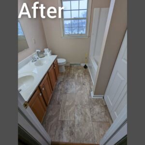 A completed bathroom renovation with new vanity and tiled floor by Adam's Handyman and Contracting in Lancaster, PA.