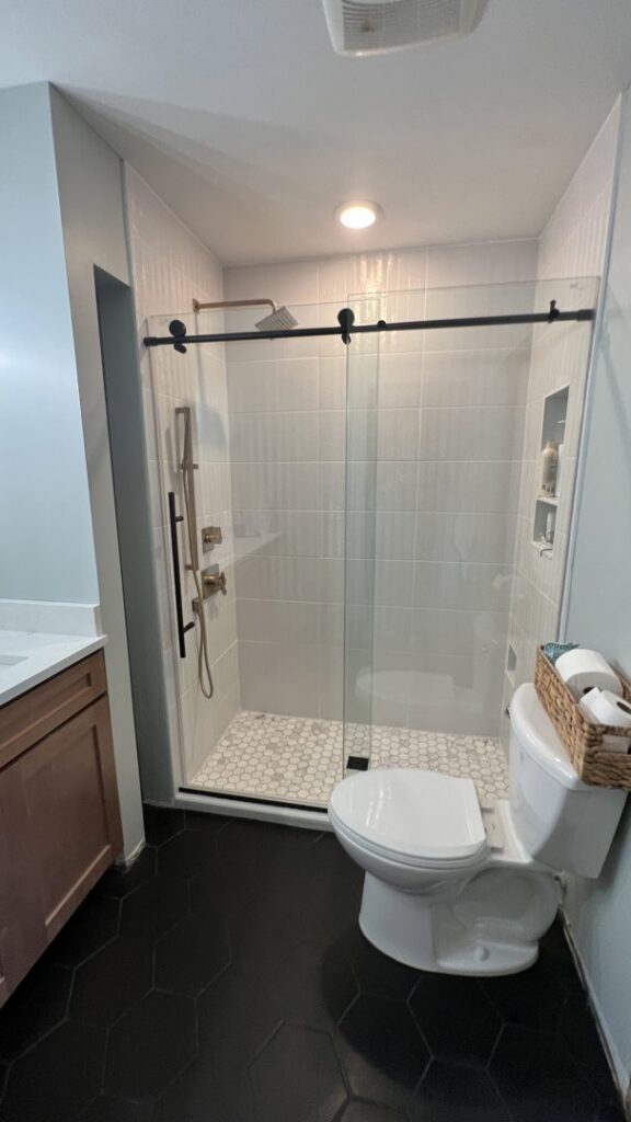 A modern bathroom renovation with new shower, toilet, and hexagon floor tile installed by Clear Choice Handyman LLC in Woodbury, MN.