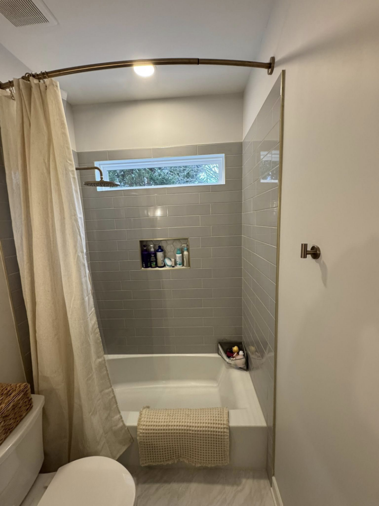 A newly tiled bathroom shower and tub combination with gray subway tiles by Branch Home Improvement LLC in Raleigh, NC.
