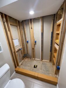 A bathroom shower area under construction, showing framing and plumbing work by Inspired Renovation & Hardscape's in Lorain, OH.