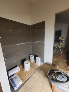 A bathroom shower area under construction with cement board installed, ready for tiling by Tile Works inc in Naperville, IL.