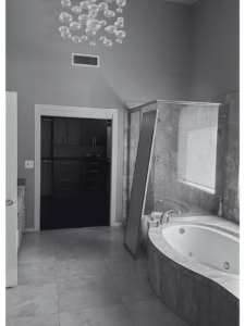 A bathroom showing a shower door panel being installed or repaired by 180 Degrees Design + Build in Phoenix, AZ