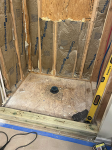 Bathroom shower framing and construction in progress, showing insulation and plumbing by Ingram Painting and Renovation in Birmingham, AL.