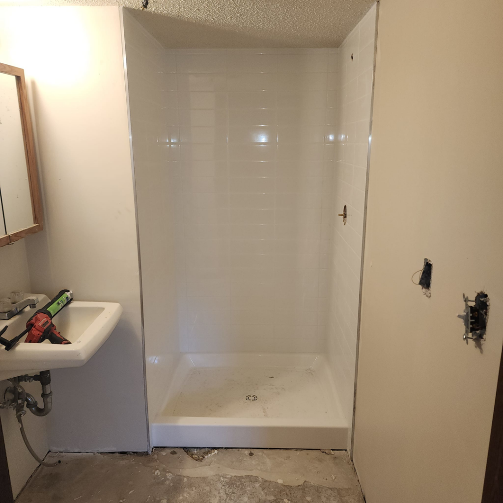 A new shower stall and sink being installed during a bathroom renovation by Excalibur Home Services in Council Bluffs, IA.