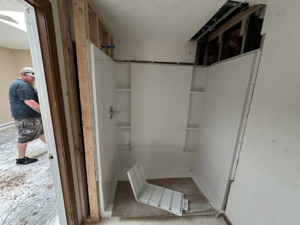 A bathroom renovation in progress with a new shower stall being installed by ThoroughFair Renovations in Lawrence, KS.
