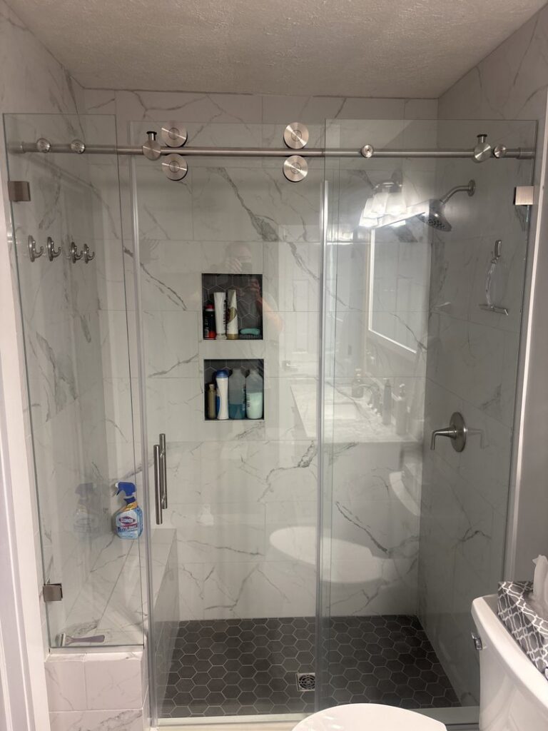 Modern bathroom shower enclosure with glass doors and tile work by True North Builders in Franktown, CO.