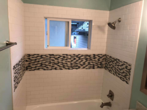 Bathroom shower remodel with white subway tile and mosaic accent by All in One Remodeling Services LLC in East Sandwich, MA