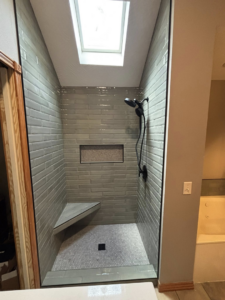 A complete bathroom shower remodel featuring a skylight and new tiling by Craft Tile Co in Springfield, MO.