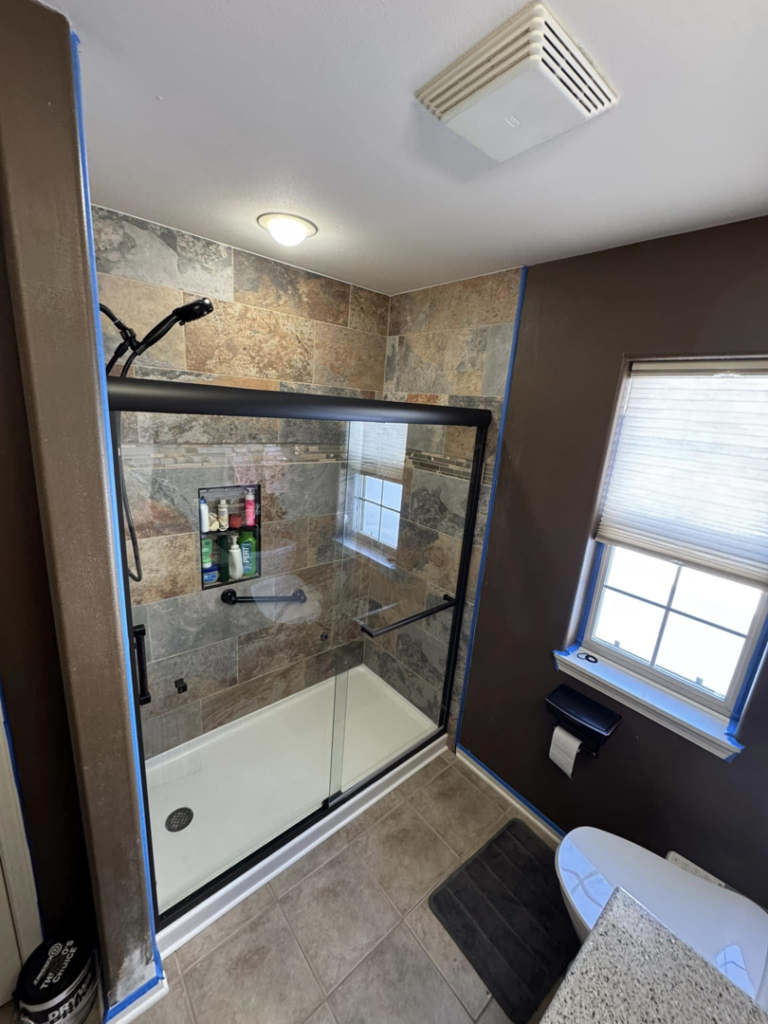 A bathroom shower renovation featuring new tiling and recent painting work by Home Improvements by Duane in Racine, WI.