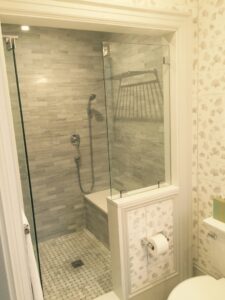 A newly installed bathroom shower with modern tile and glass enclosure by Connaughton Construction in Waltham, MA