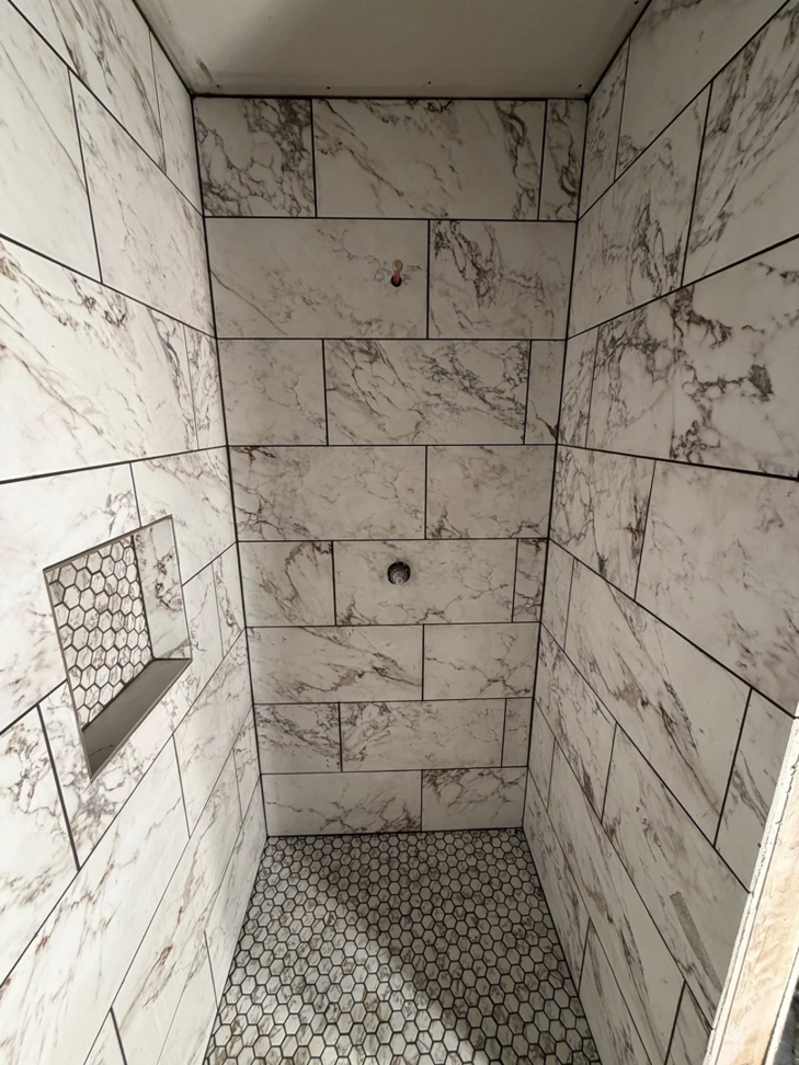 Expert bathroom shower tile installation with marble-look and hexagonal tiles by GE Renovations LLC in Albertville, AL