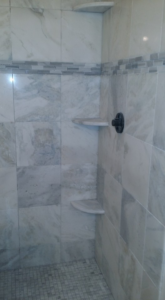 Interior of a newly tiled bathroom shower with built-in shelves by Gudiño's Tile and Natural Stone in Glendale, AZ