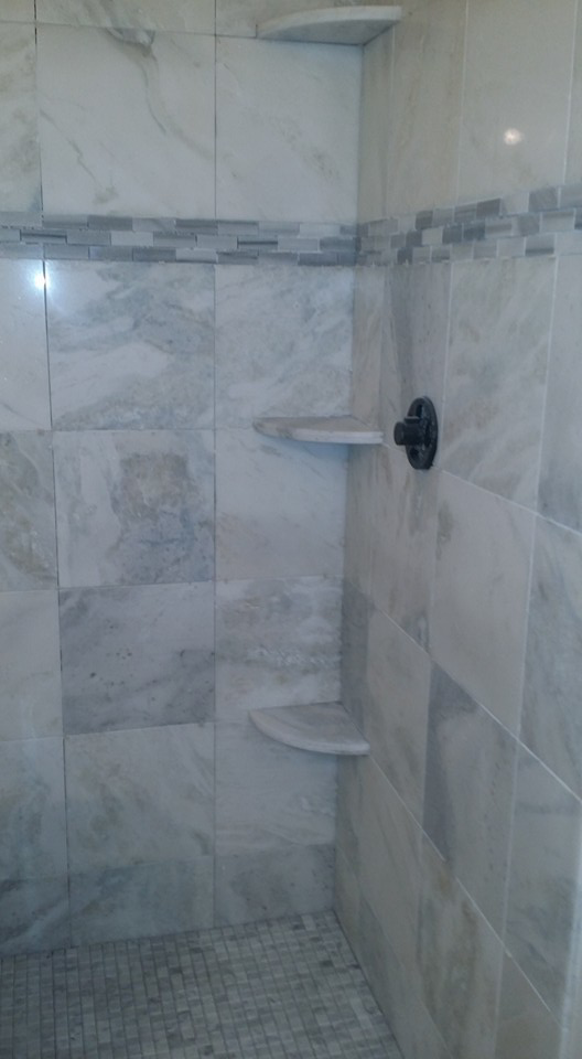Interior of a newly tiled bathroom shower with built-in shelves by Gudiño's Tile and Natural Stone in Glendale, AZ