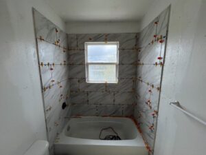 Bathroom shower tile installation in progress with spacers by High Plains Craftsmen in Cheyenne, WY.
