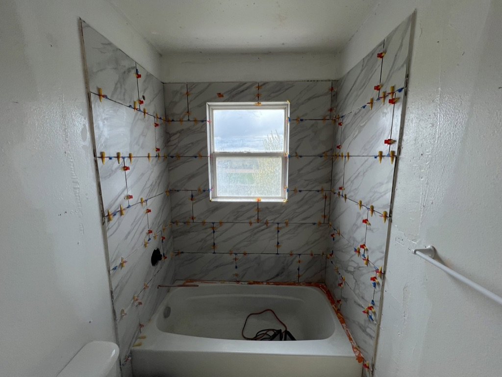 Bathroom shower tile installation in progress with spacers by High Plains Craftsmen in Cheyenne, WY.
