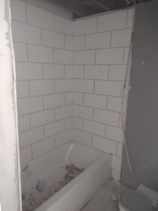 Bathroom shower area with new subway tile installation in progress by I.B. Remodeling LLC in Dayton, OH.