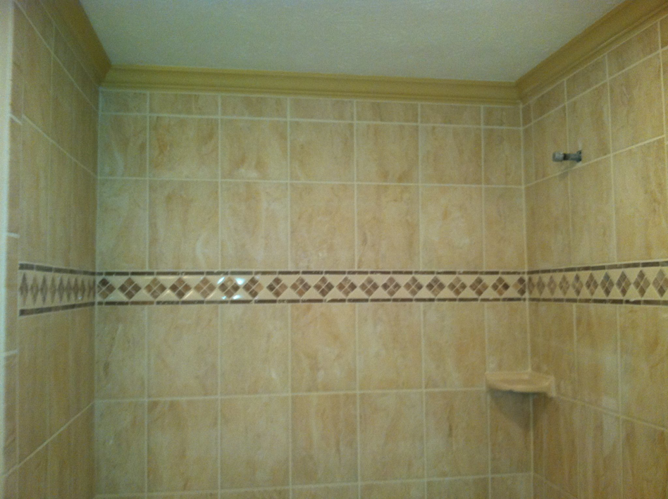 Newly installed bathroom shower tiles with a decorative border by Mason Home Improvement Inc. in Newport News, VA.