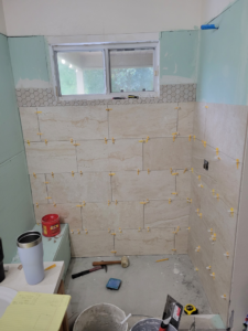 Bathroom shower walls during tile installation, a project by Williams Custom Construction in Orlando, FL.