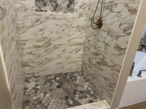 The interior of a beautifully tiled shower with a built-in niche by Ingram Painting and Renovation in Birmingham, AL.