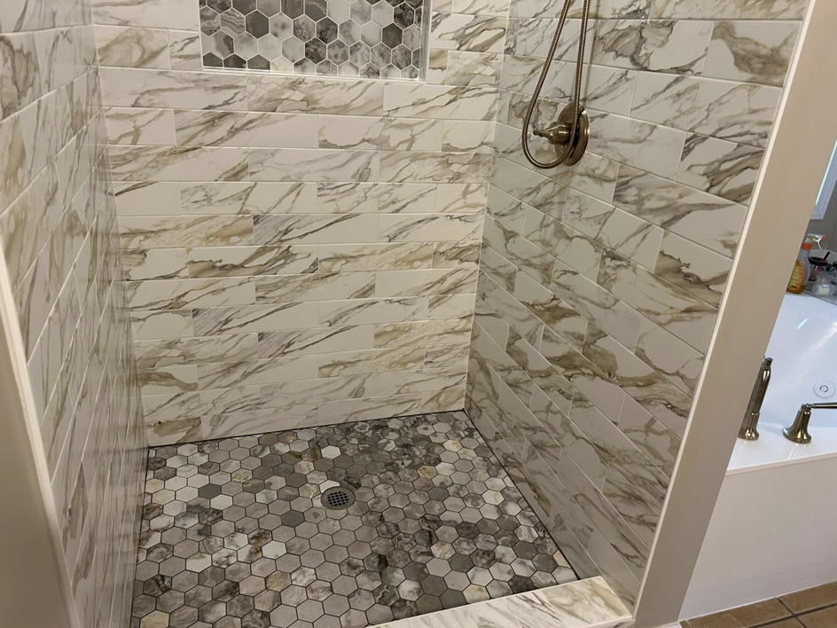 The interior of a beautifully tiled shower with a built-in niche by Ingram Painting and Renovation in Birmingham, AL.