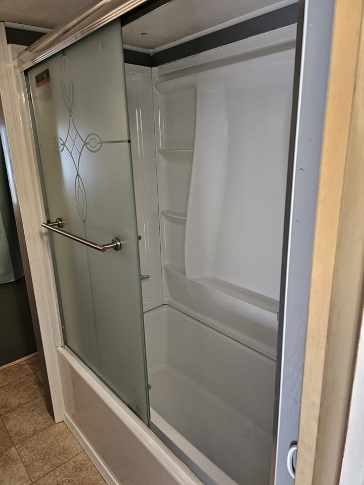 A newly installed shower and tub combination with a sliding glass door by Fairbanks Finest Handyman in Fairbanks, AK.