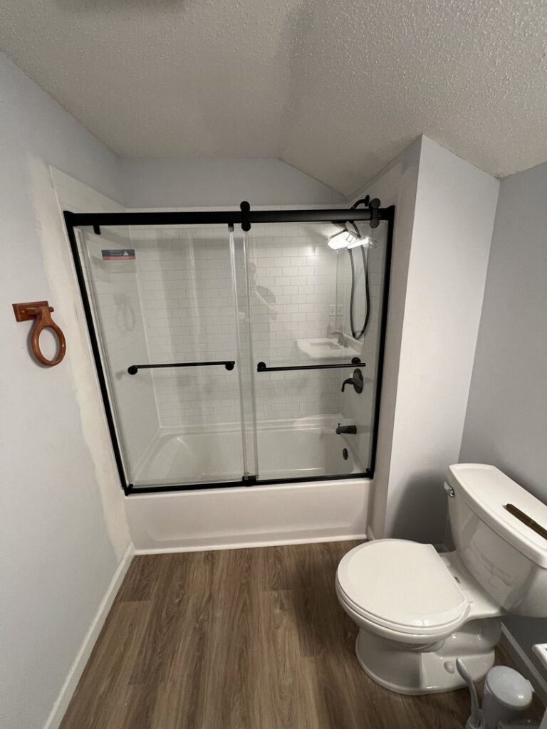 A newly installed shower and tub combination with sliding glass doors by Garbatini Contracting in Wallingford, CT.