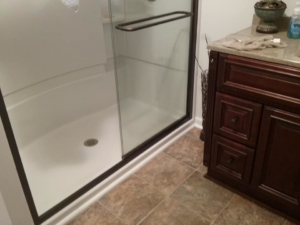 A newly installed shower enclosure and vanity with granite countertop in a bathroom by The House Doctor in Hopkinsville, KY.