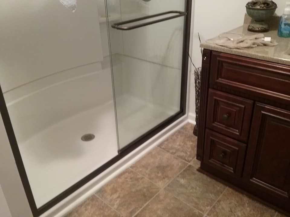 A newly installed shower enclosure and vanity with granite countertop in a bathroom by The House Doctor in Hopkinsville, KY.