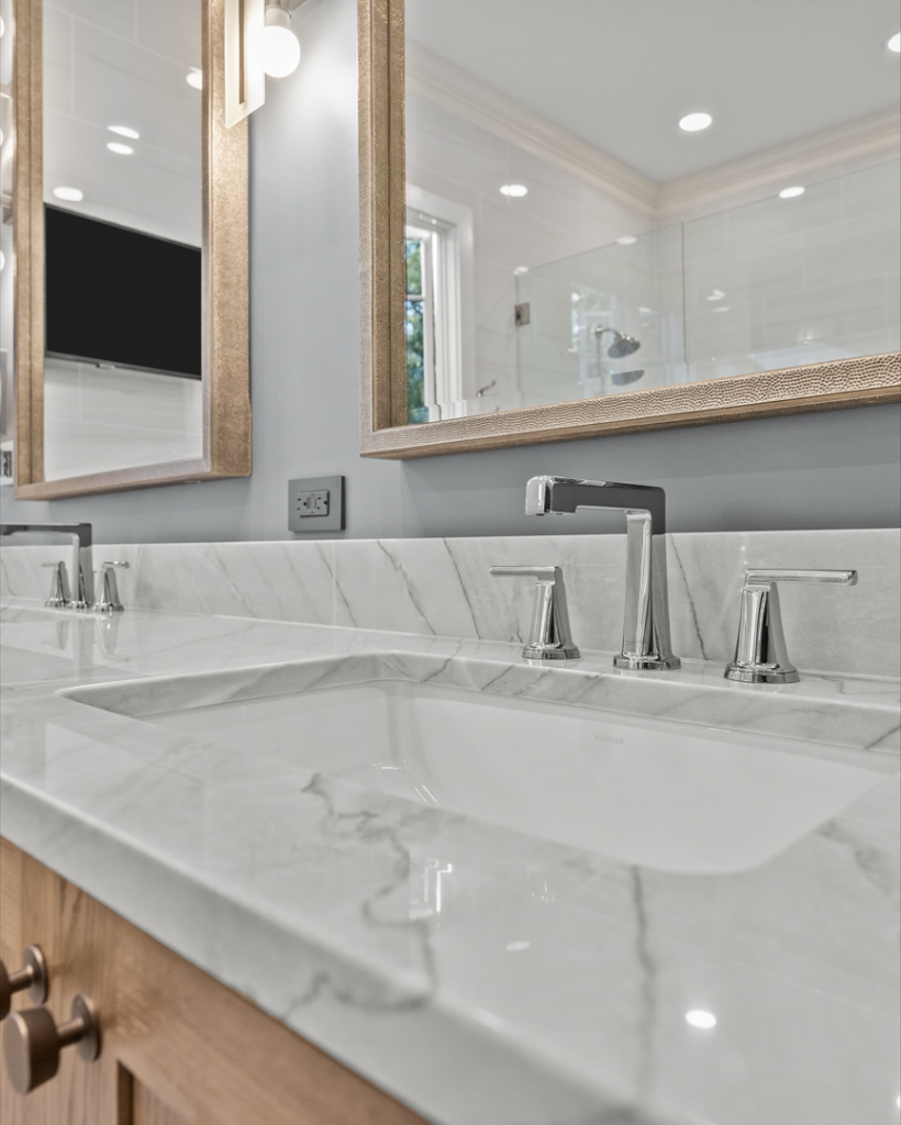 A close-up of a newly installed bathroom sink, modern faucet, and marble countertop by Blue Ribbon Residential Construction, Inc. in Raleigh, NC.