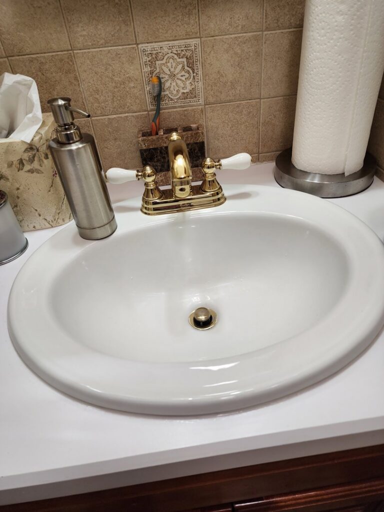 A newly installed bathroom sink with a gold faucet, showcasing plumbing services by Clear Flow Plumbing, Heating, and Hvac Contractors LLC in Jersey City, NJ