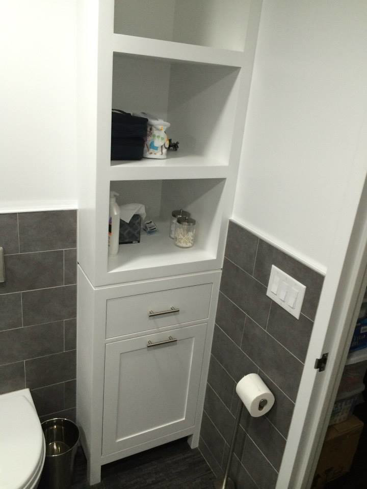 A tall white bathroom storage cabinet and shelving unit next to a toilet, installed by Executech Interiors in Yonkers, NY