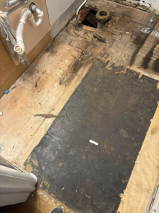A bathroom subfloor with old flooring removed, showing preparation for new installation by CJ Flooring LLC in Flat Rock, MI.