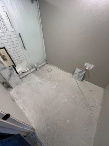 Bathroom floor with new tiles laid out, showing flooring installation in progress by Elite Flooring Professionals in Pueblo, CO.