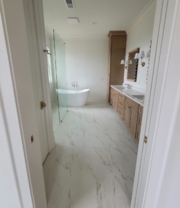 A newly installed marble-look tile floor in a modern bathroom by Williamson Flooring & Design Center in Rock Hill, SC