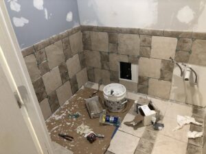A bathroom undergoing renovation with new wall tiles being installed by HandyVets in Saint Charles, MO.