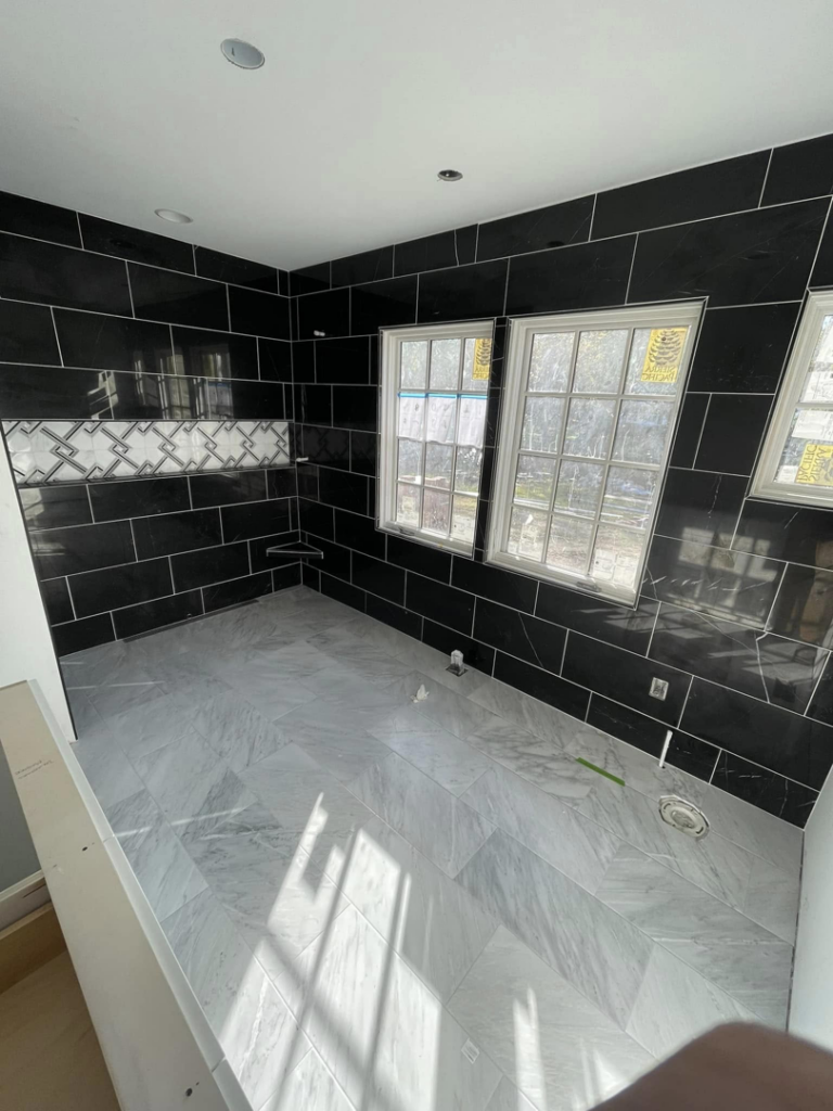 A bathroom tile installation in progress with black subway and grey floor tiles by A&L Tile LLC in San Diego, CA