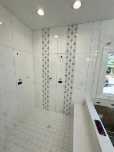 Bathroom tile installation in progress with white and patterned grey tiles by Bohannon Custom Tile and Renovation in Virginia Beach, VA.