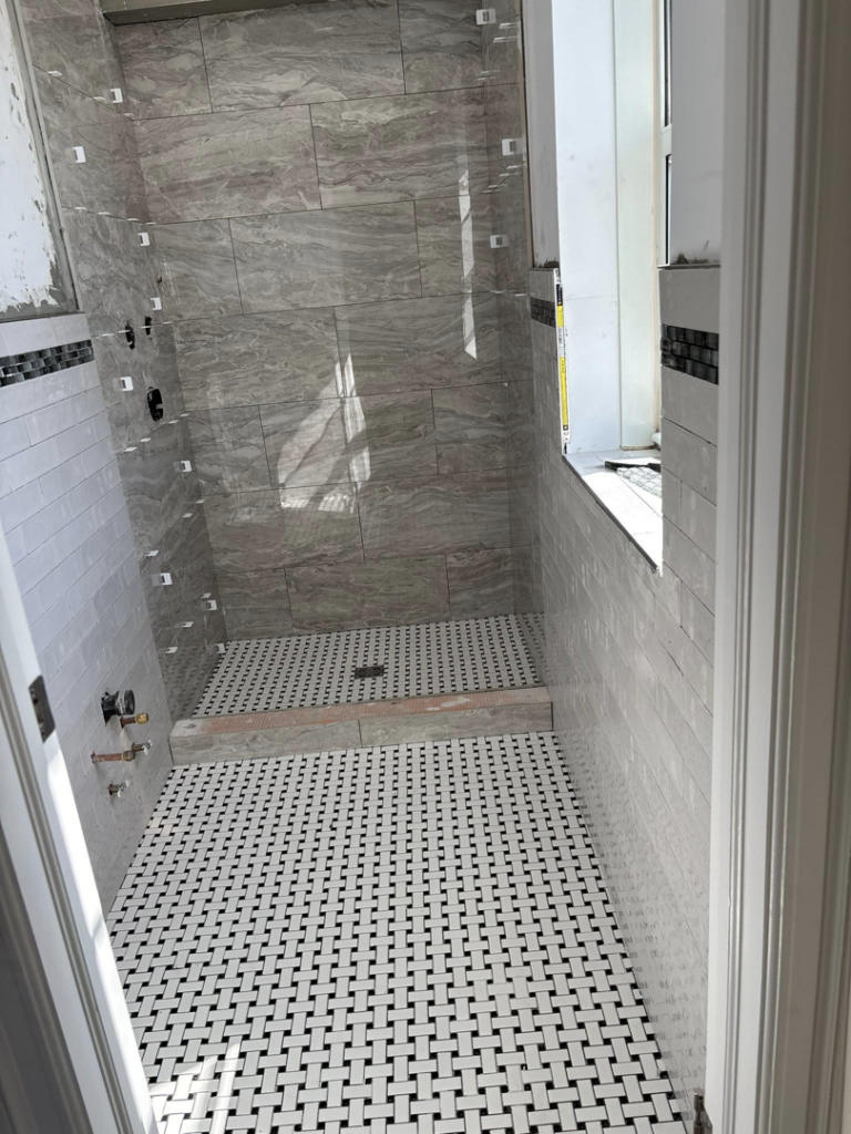 Bathroom tile installation in progress with basketweave floor tiles by Golden Tile Construction in Yonkers, NY.