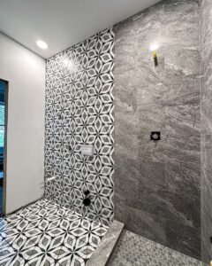 Bathroom tile installation in progress, showing patterned floor and wall tiles by Kore Construction LLC in Cincinnati, OH.